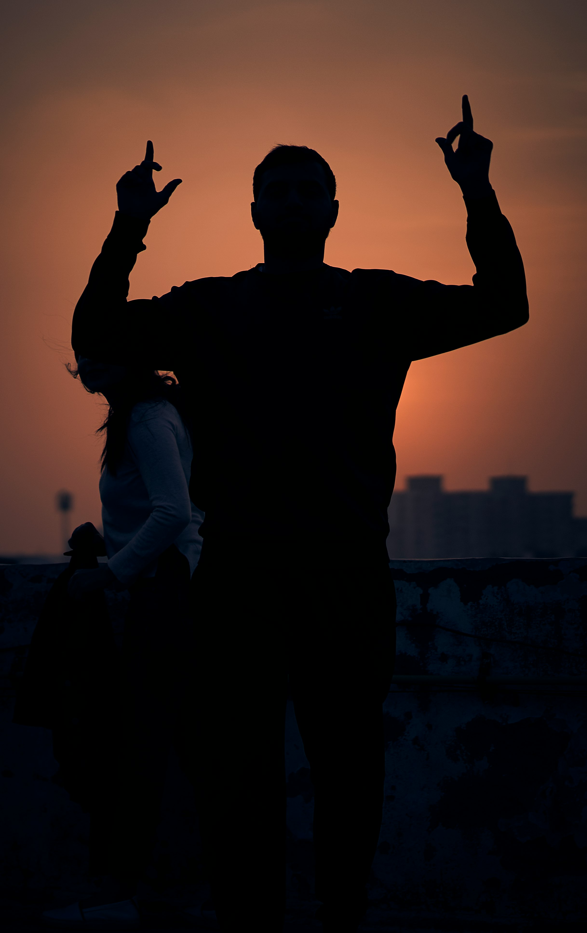 man in black crew neck t-shirt standing on gray concrete wall during daytime